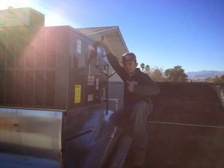 HVAC technician performing Heat Pump Repair on a rooftop unit in Stevensville